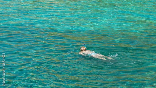 Woman Snorkeling in Clear Blue Mediterranean Sea Water at Anthony Quinn Bay in Rhodes Greece photo