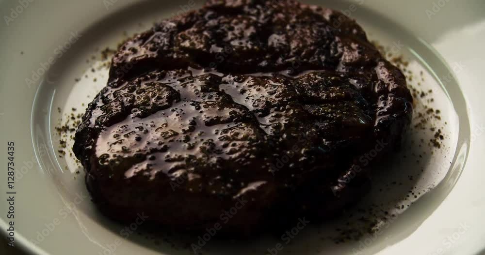 Serving grilled meat steak 4k rotation video top view. Chef puts fried beef on plate in barbecue restaurant. BBQ beefsteak Serving grilled meat steak 4k rotation video top view. Chef puts fried beef on plate in barbecue restaurant. BBQ beefsteak