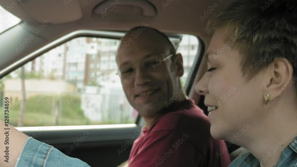 Couple man and woman in a car talk smile and laugh and man leaves a car. POV from outside driver's window. Urban exploring driving and family scene. Couple man and woman in a car talk smile and laugh and man leaves a car. POV from outside driver's window. Urban exploring driving and family scene.