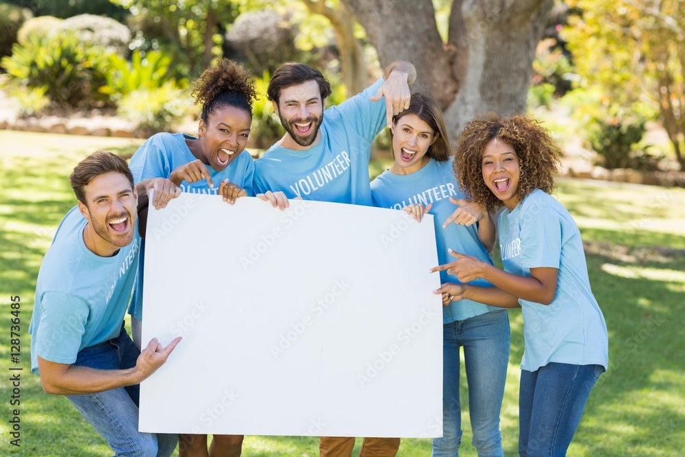 Group of volunteer holding a blank sheet and pointing to it Group of volunteer holding a blank sheet and pointing to it
