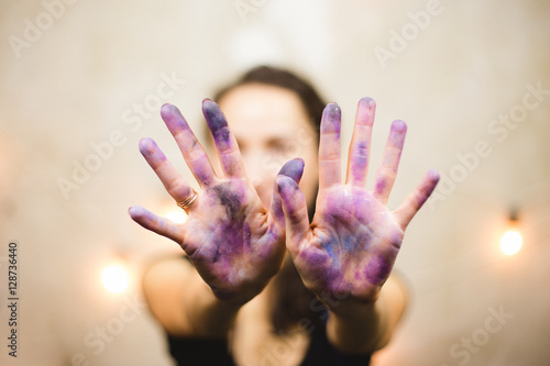 the artist's hand in the paint and sequins space