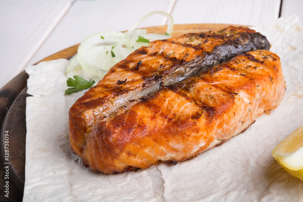Fried salmon served on wooden board Fried salmon served on wooden board