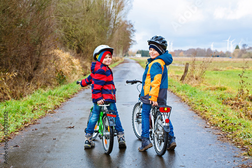 Fototapeta Naklejka Na Ścianę i Meble -  Little preschool kids boys riding on bicycle