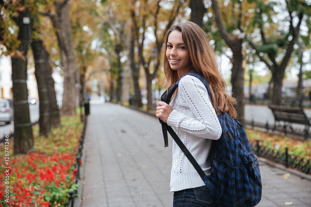 Cheerful attractive young woman with backpack walking in park Stock ...