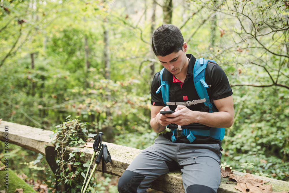 Hiker looking on smartphone in nature Hiker looking on smartphone in nature
