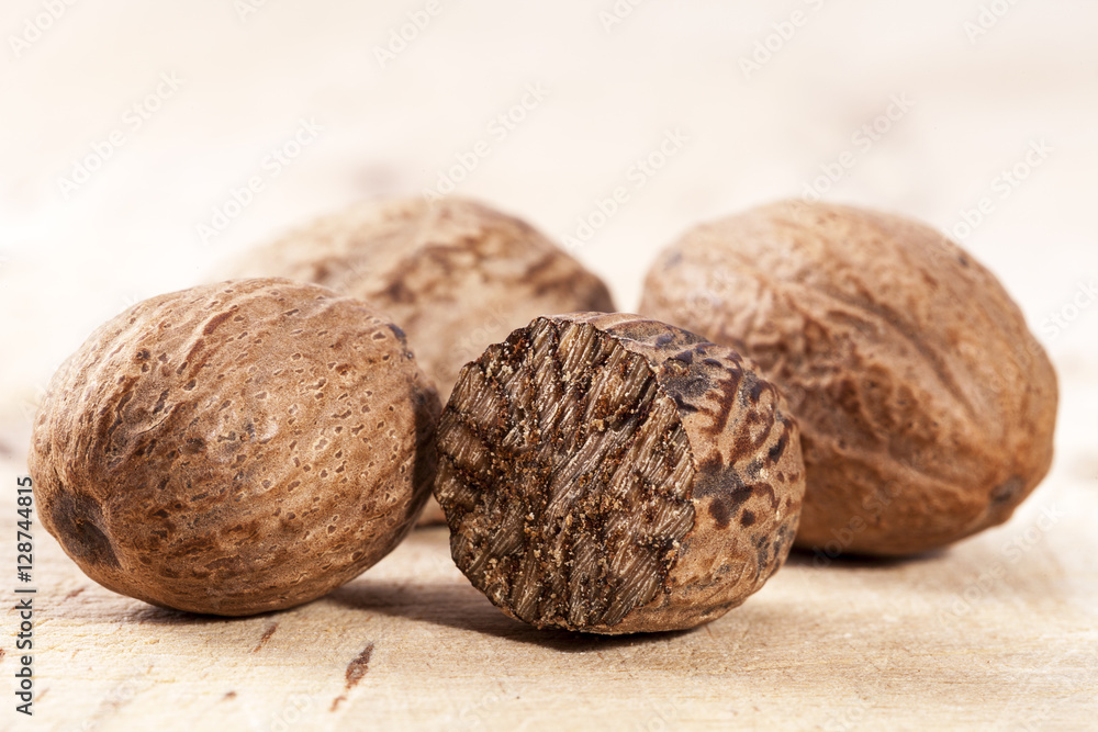 Nutmeg , whole and half on wooden plank, close up Nutmeg , whole and half on wooden plank, close up