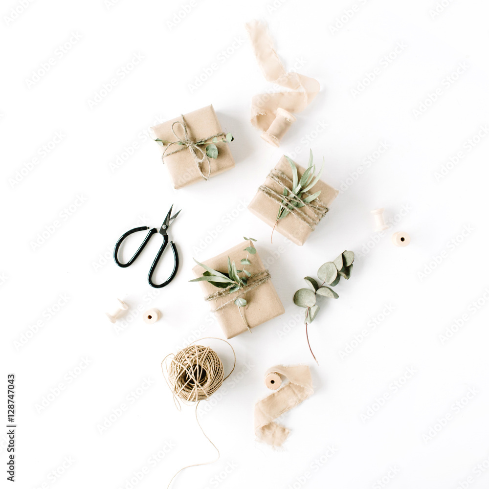 creative arrangement pattern of craft boxes and green branches on white background. flat lay, top view creative arrangement pattern of craft boxes and green branches on white background. flat lay, top view