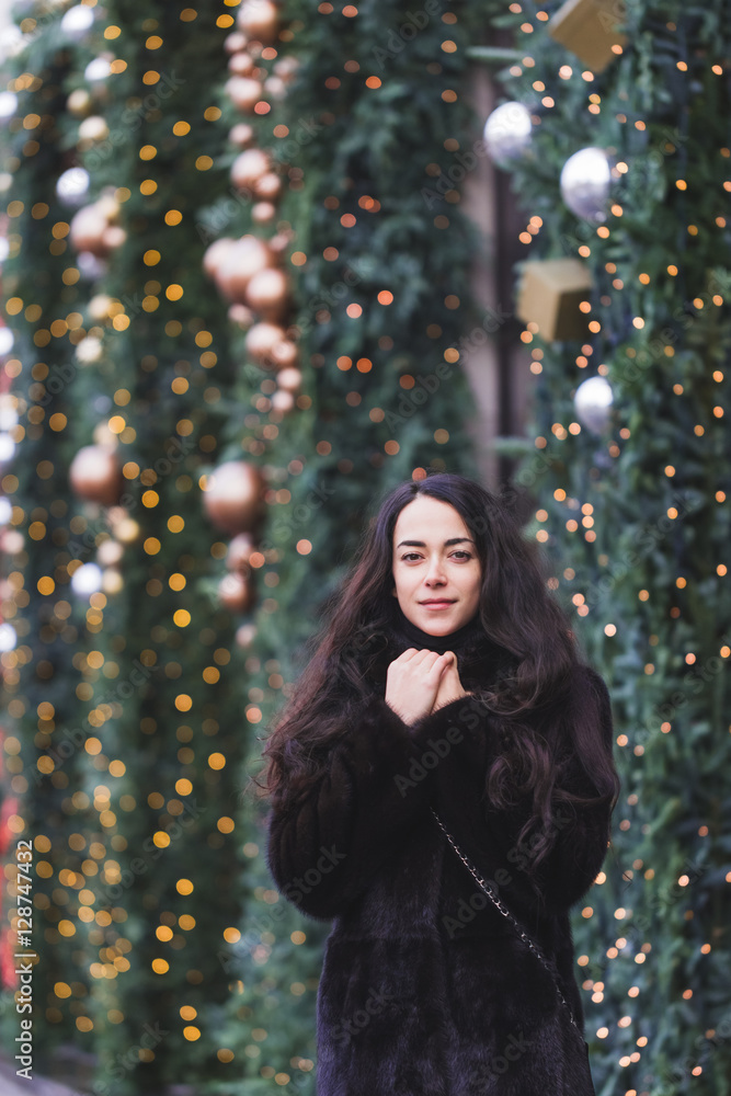 Happy woman walking in a black mink coat in city, beautifully de Happy woman walking in a black mink coat in city, beautifully de