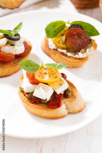 bruschettas with tomatoes and mozzarella on plate, vertical