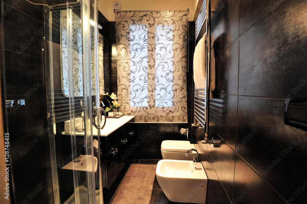 Italian bathroom with black wall / tiles and white forniture / services. A warm  light illuminates the room Stock Photo | Adobe Stock