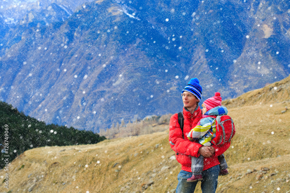 father and little daughter travel in winter mountains