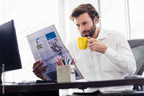 Businessman drinking coffee and reading newspapper photo
