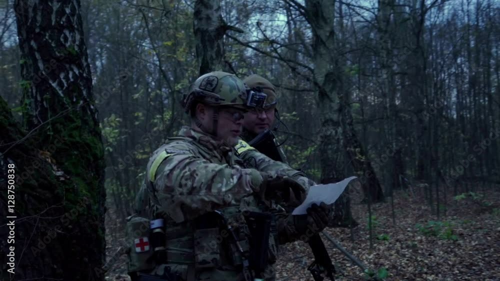 war in the woods with a gun looking at the map war in the woods with a gun looking at the map