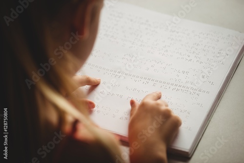 Girl using braille to read photo