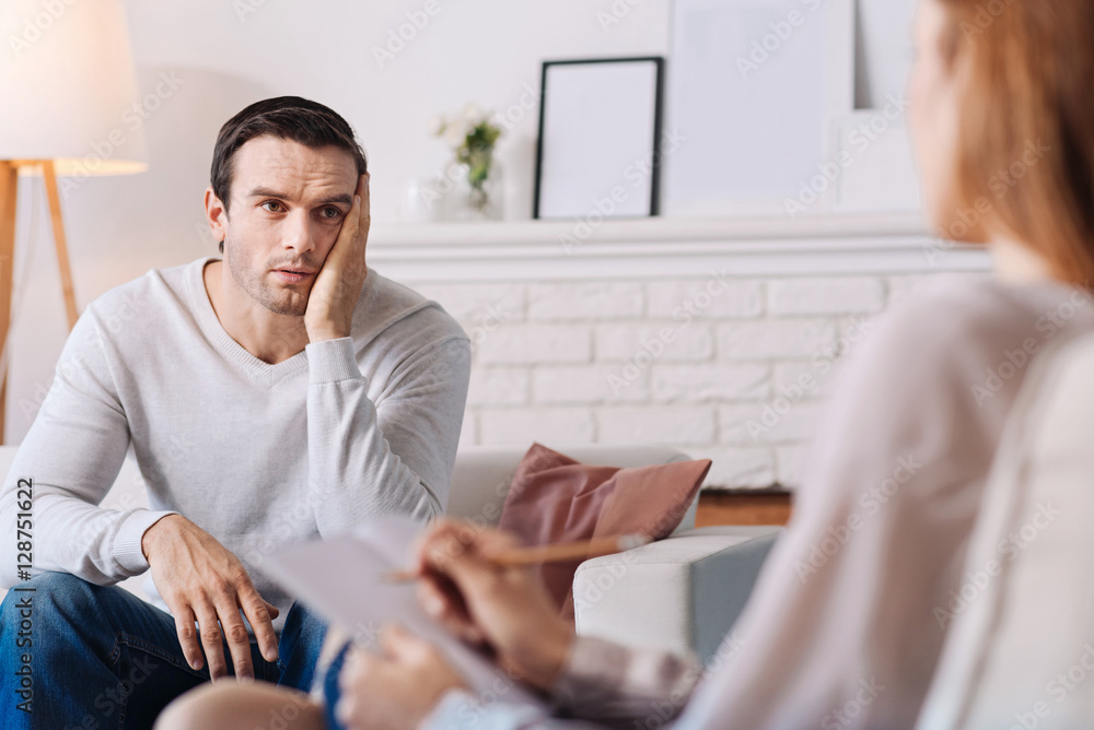 Pleasant moody man talkign with professional psychologist Pleasant moody man talkign with professional psychologist