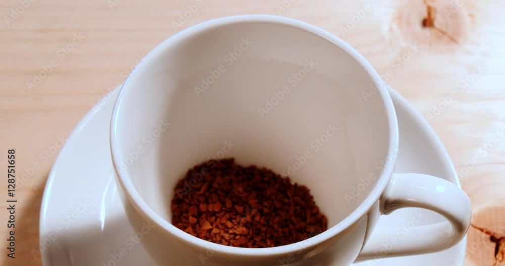 Pouring Instant coffee from tea spoon to a white cup Pouring Instant coffee from tea spoon to a white cup