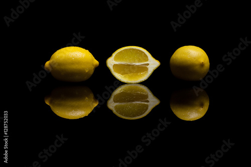Three  yellow lemons on black background