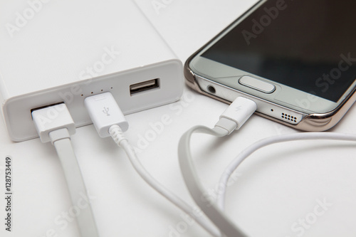 charging smart phone with portable battery on white backgrounds