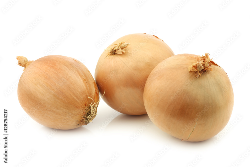 three big brown onions on a white background three big brown onions on a white background