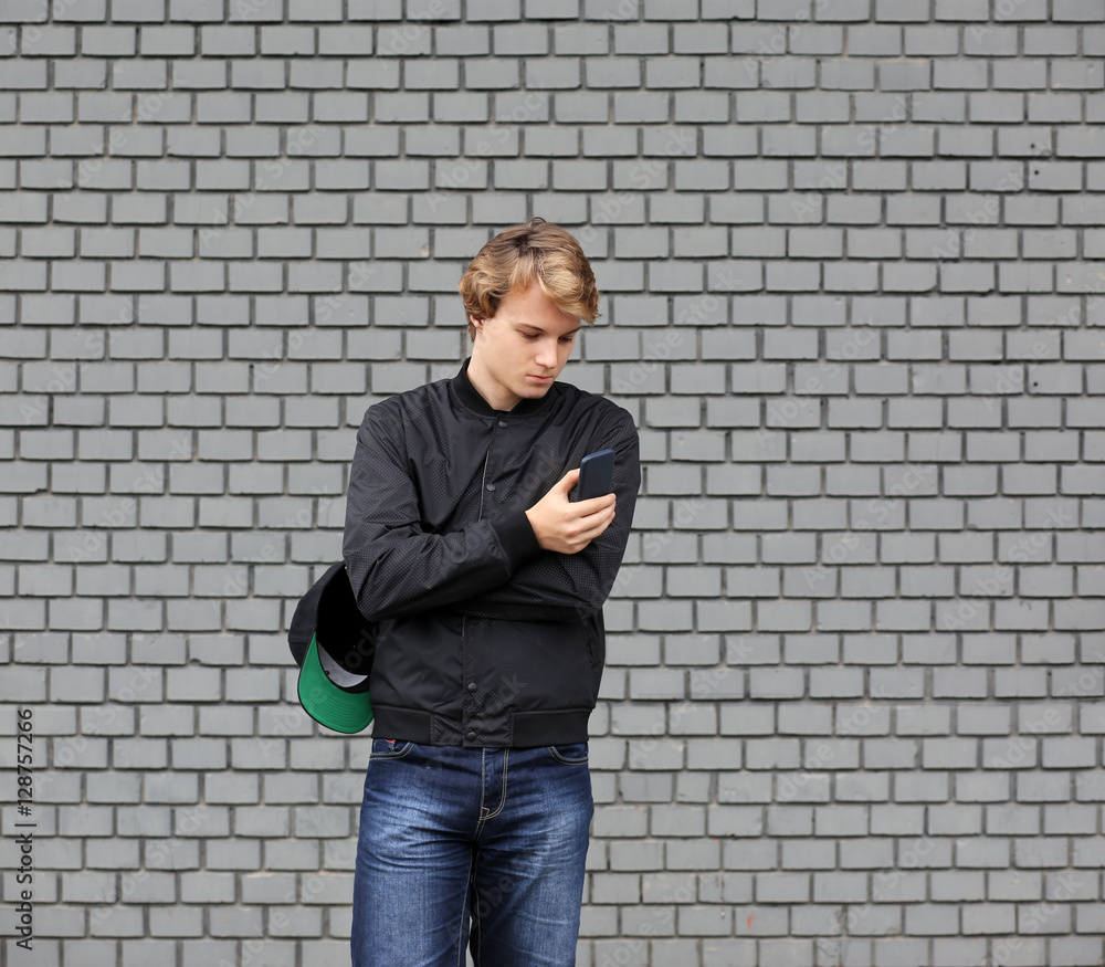 Smiling teenage boy typing text message.Using smart phone. Smiling teenage boy typing text message.Using smart phone.