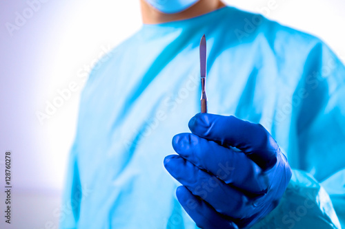 Man surgeon holds a scalpel in an operating room