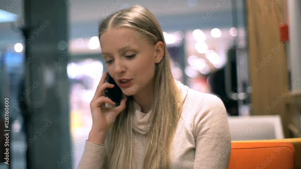 Pretty, blonde girl chatting on cellphone and smiling to the camera
Pretty, blonde girl chatting on cellphone and smiling to the camera