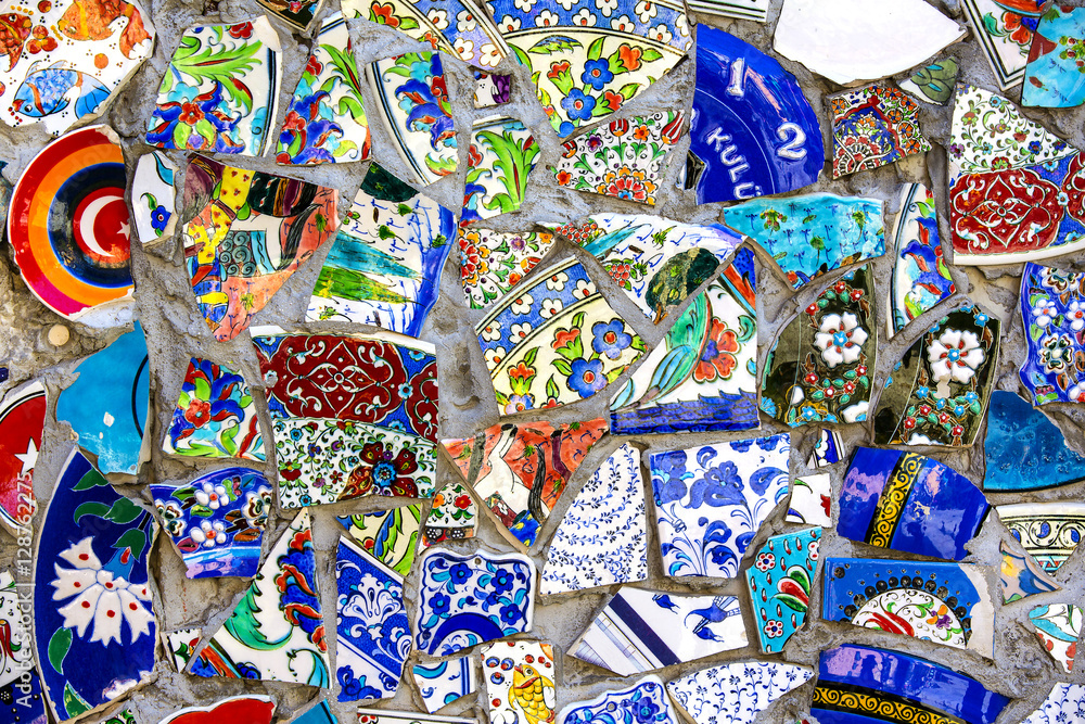 Fototapeta premium Wall with broken ceramic plates colored fragments
