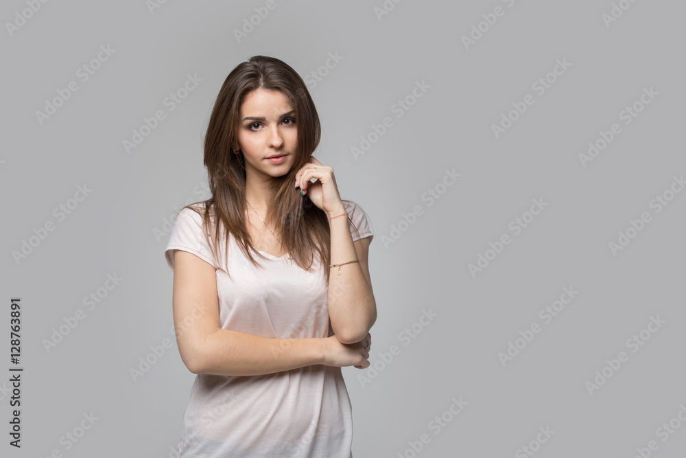 Portrait of beautiful brunette woman with natural make-up, on grey background Portrait of beautiful brunette woman with natural make-up, on grey background