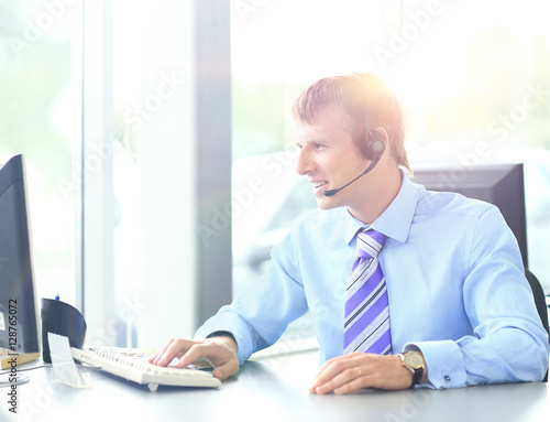 Happy young man working at callcenter, using headset © ASDF