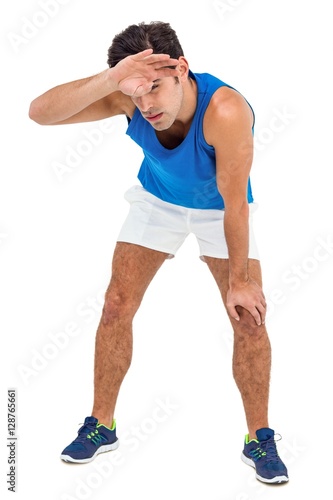Tired athlete wiping his sweat with hand