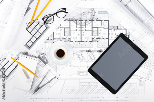 Construction plans with Tablet and drawing Tools on blueprints