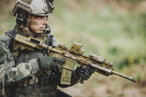 Quadro su tela Portrait of a soldier in the battlefield with a rifle