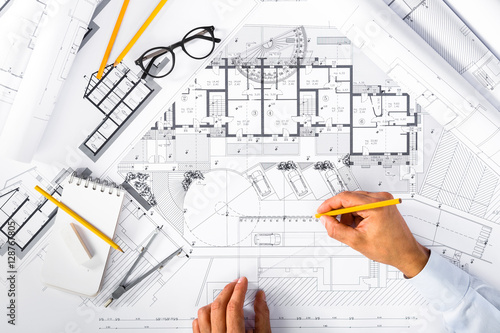 Construction plans and Male Hands drawing on blueprints
