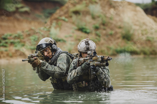 Fotografie Military team crossing the river under fire