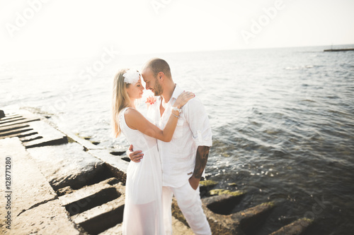 happy just married young wedding couple celebrating and have fun at beautiful beach sunset © olegparylyak