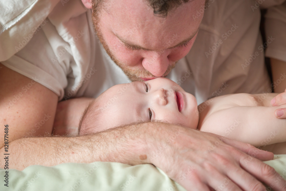Mixed Race Chinese and Caucasian Baby Boy Laying In Bed with His Father. Mixed Race Chinese and Caucasian Baby Boy Laying In Bed with His Father.