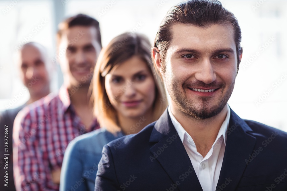 Smiling businessman with coworkers standing in row Smiling businessman with coworkers standing in row