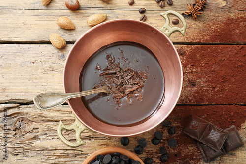 Foto cioccolato fuso in tegame di metallo sfondo rustico