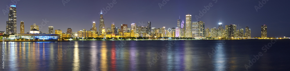 Night panoramic picture of Chicago city skyline with reflection in Lake Michigan.