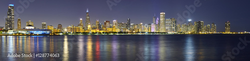 Night panoramic picture of Chicago city skyline with reflection in Lake Michigan.