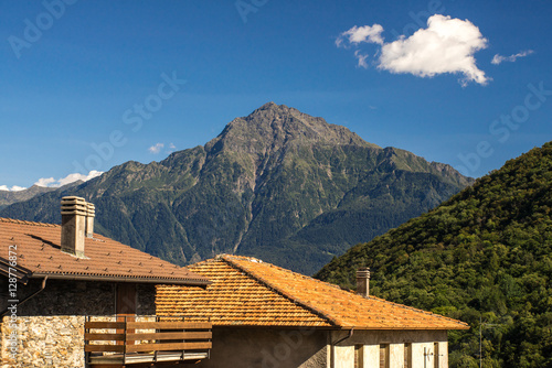 Old Italian village. Stone and tale roofs, mountains.