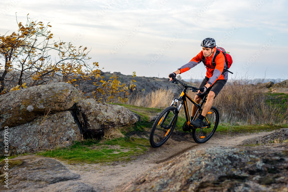 Cyclist in Red Jacket Riding the Bike on Rocky Trail. Extreme Sport.