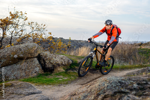 Cyclist in Red Jacket Riding the Bike on Rocky Trail. Extreme Sport. © Maksym Protsenko