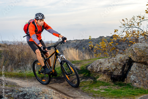 Cyclist in Red Jacket Riding the Bike on Rocky Trail. Extreme Sport.