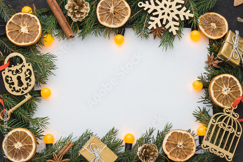 Christmas, New Year background and frame with fir, dry citrus, spices and string lights