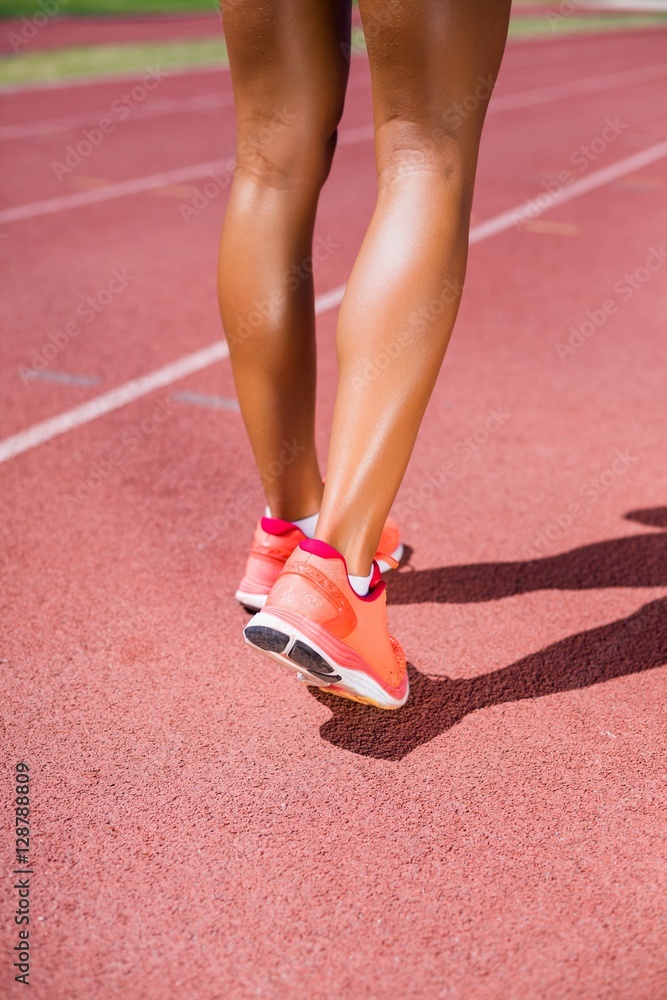 Female athlete running on the racing track Female athlete running on the racing track