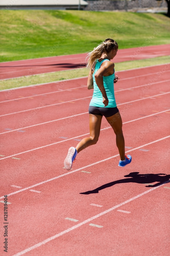 Female athlete running on the racing track