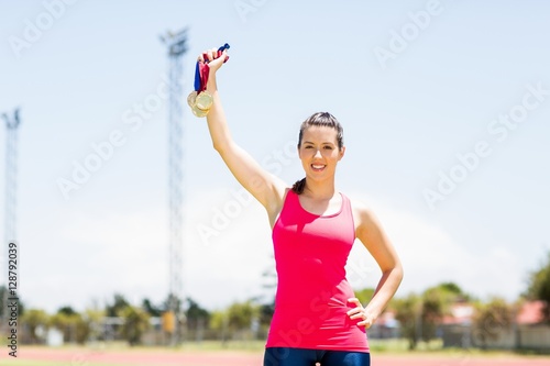 Portrait of female athlete showing her gold medals