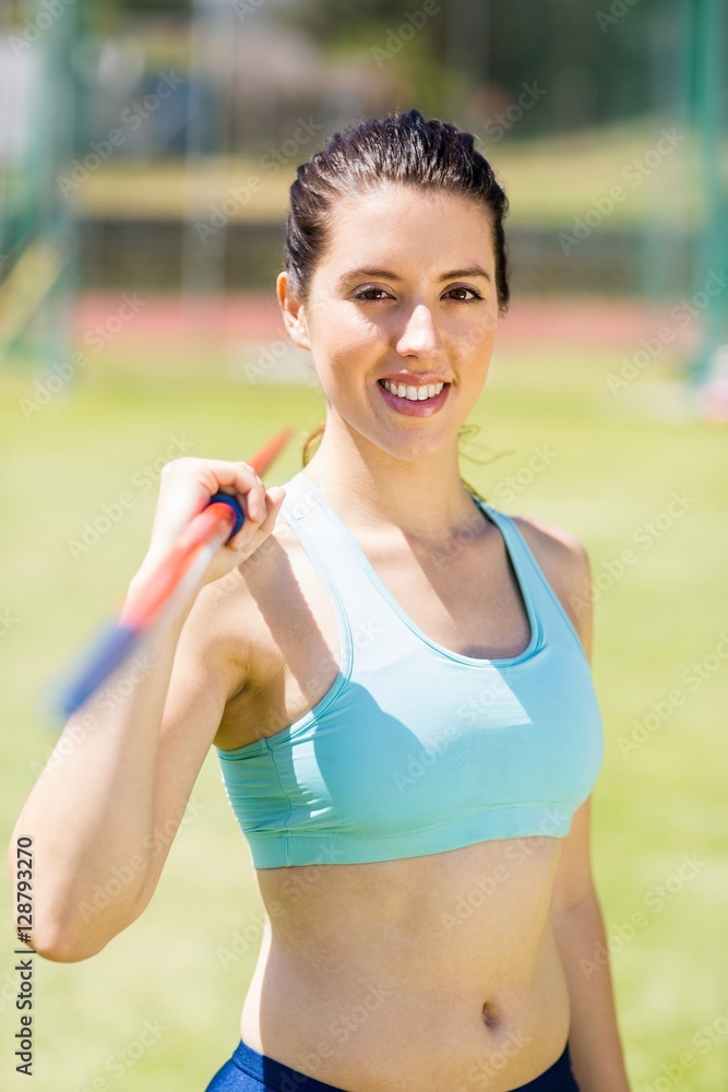 Fototapeta premium Portrait of female athlete holding a javelin