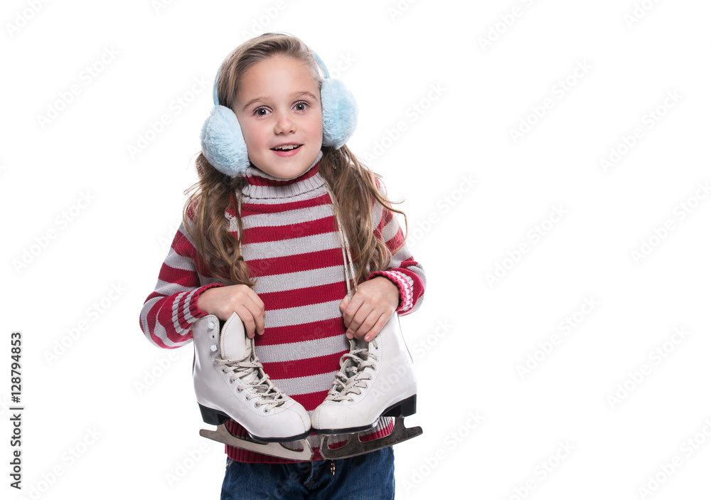 Lovely smiling little girl wearing colorful striped sweater and headdress, holding skates isolated on white background. Winter clothes. Lovely smiling little girl wearing colorful striped sweater and headdress, holding skates isolated on white background. Winter clothes.
